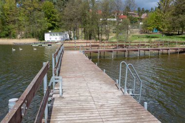 Orta Avrupa'da boş yüzme havuzu. Gölde ahşap iskele.