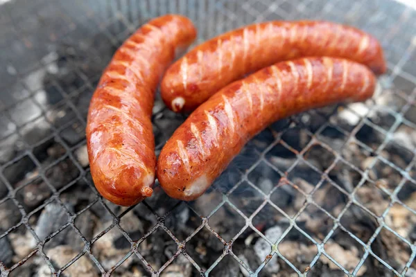 Stek korv på grillen. Förbereda en måltid på en Camping. — Stockfoto