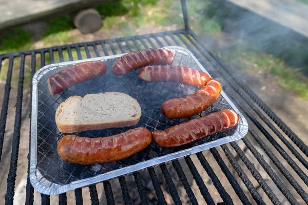 Roast sausage on the grill. Preparing a meal on a camping. — Stock Photo, Image