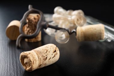 Fermantasyon tüpü ve siyah bir masa üzerinde tirbuşon. Aksesuarlar ne