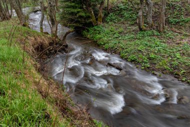 Dağlık arazide hızlı bir dere. Nehirde akan su uzun pozlama da gösterilmiştir. Bahar Mevsimi.