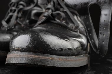 Eski siyah ordu botları yağmurdan ıslanıyor. Di'ye dayanıklı ayakkabı