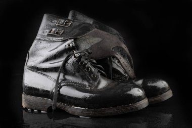 Eski siyah ordu botları yağmurdan ıslanıyor. Di'ye dayanıklı ayakkabı