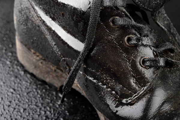 Old black army boots wet from the rain. Footwear resistant to di