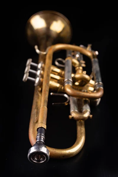 Vieja trompeta sobre una mesa de madera oscura. Instrumento de viento en el viejo s — Foto de Stock