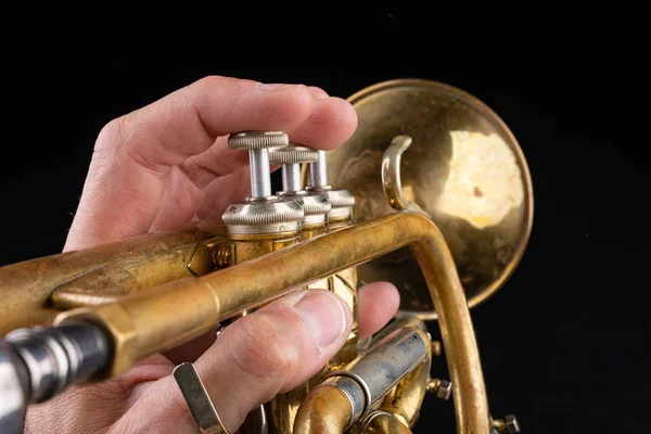 Old trumpet on a dark wooden table. Wind instrument in the old s — Stock Photo, Image