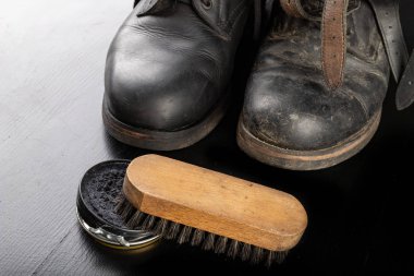 Ayakkabı cilası, fırça ve siyah askeri botlar. Parlatma ve temizleme