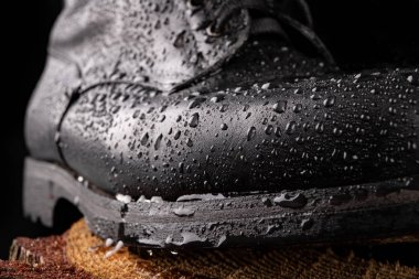 Siyah askeri botlar ve yağmur damlaları. Iyi korunmuş eski çizmeler fo