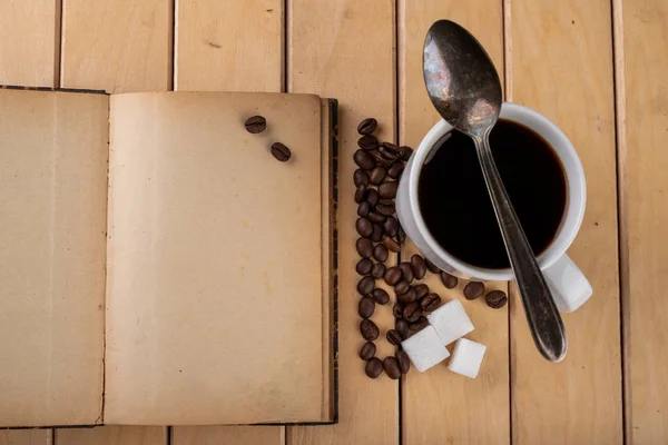 Tazza bianca con caffè nero su un tavolo di legno. Grani di caffè — Foto Stock