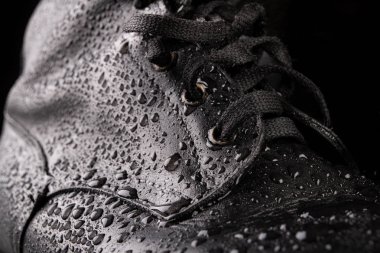 Siyah askeri botlar ve yağmur damlaları. Iyi korunmuş eski çizmeler fo