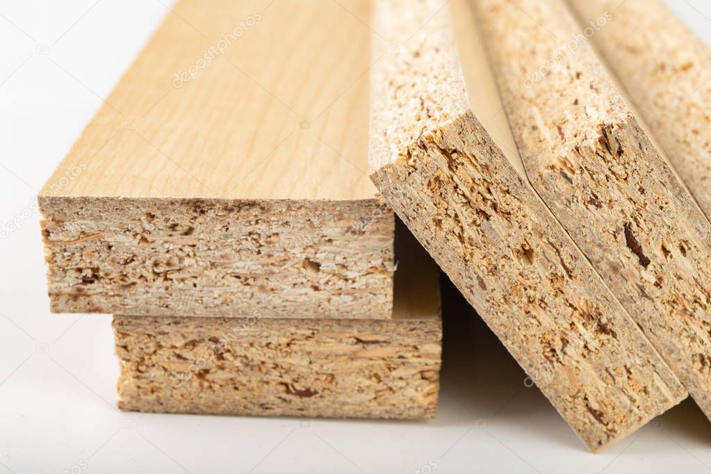 Particleboard with veneer is cut into small pieces. Materials fo