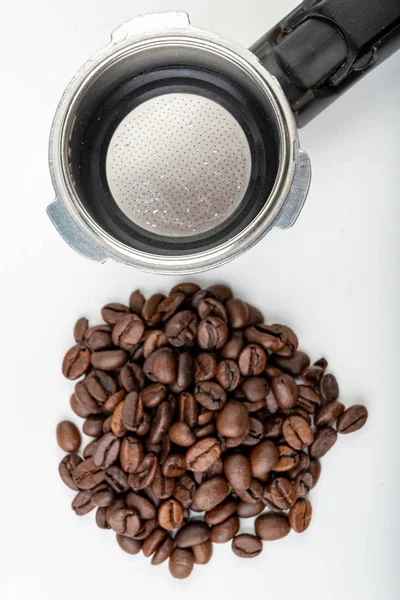 Black roasted coffee beans and a coffee machine flask. Coffee ma