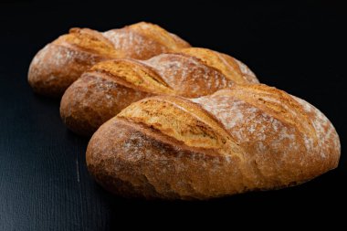 Koyu bir masada taze pişmiş lezzetli ekmek. Lezzetli pişmiş mal Str