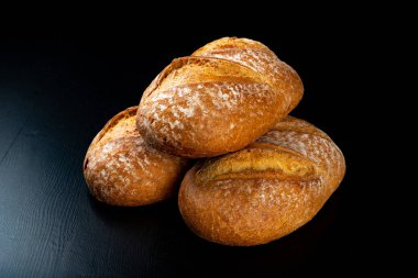 Koyu bir masada taze pişmiş lezzetli ekmek. Lezzetli pişmiş mal Str