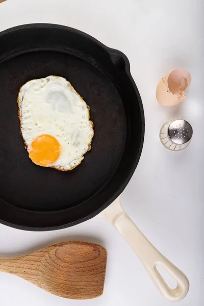 Lekker gebakken ei op een gietijzeren pan. Bereiden van een smakelijk ontbijt. — Stockfoto