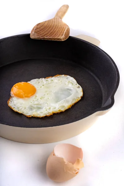 Lekker gebakken ei op een gietijzeren pan. Bereiden van een smakelijk ontbijt. — Stockfoto