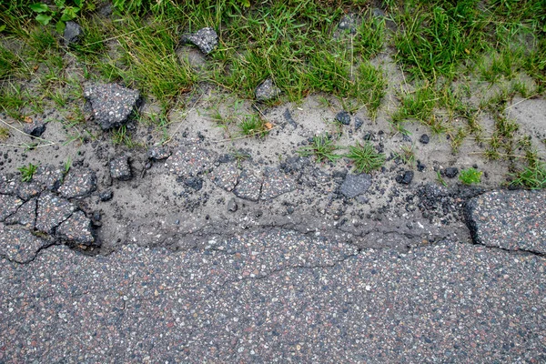 Estrada de asfalto danificada. Um buraco no caminho que leva ao cit — Fotografia de Stock