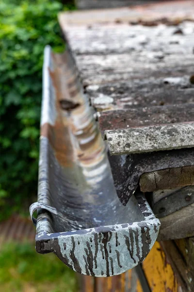 Eine alte Dachrinne in einem Einfamilienhaus. Regenwasserableitung aus dem r — Stockfoto