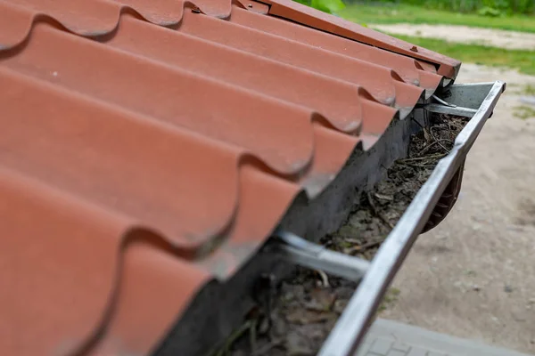 Eine alte Dachrinne in einem Einfamilienhaus. Regenwasserableitung aus dem r — Stockfoto