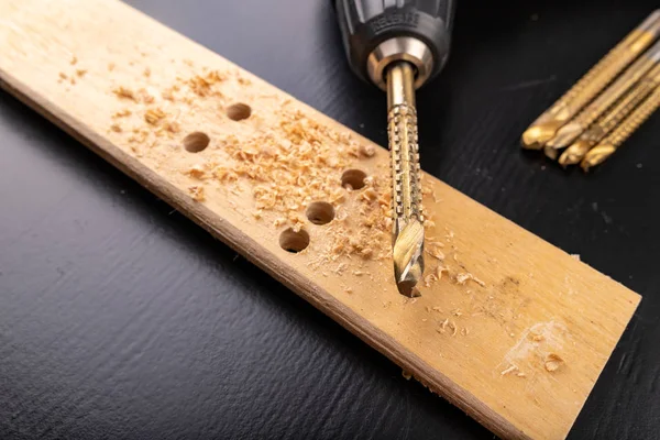 Perforación en un trozo de madera cepillada seca. Agujeros hechos en el worksh — Foto de Stock