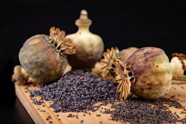 Taze haşhaş tohumları ahşap bir mutfak tahtası üzerine dökülür. Farklı po