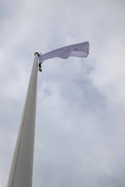 Bílá vlajka na stěžni u pláže. Příznak na pozadí c — Stock fotografie