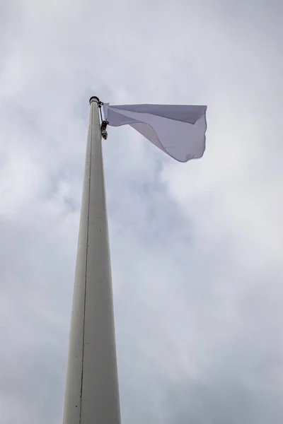 White flag on the mast near the beach. Flag on a background of c — Stock Photo, Image