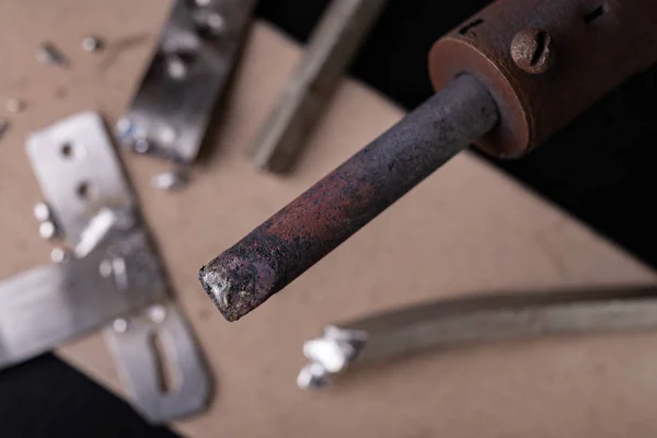 Een groot soldeerbout en soldeer toebehoren op een werkplaats t — Stockfoto