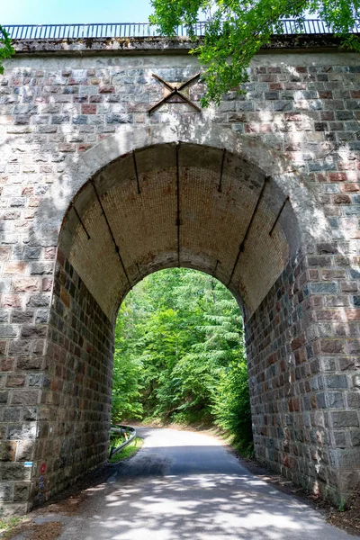 Eine alte Steinbrücke über einen kleinen Fluss. Bahnübergang — Stockfoto