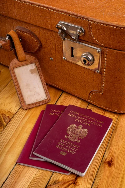 Passaporte polonês e mala de viagem em uma mesa de madeira. Accessori — Fotografia de Stock