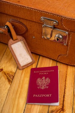 Polonya pasaportu ve ahşap bir masa üzerinde seyahat bavulu. Aksesuar