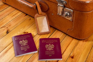 Polonya pasaportu ve ahşap bir masa üzerinde seyahat bavulu. Aksesuar