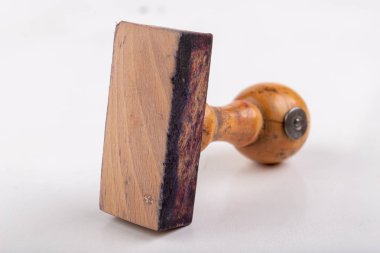 Ofiste kullanılan eski bir tahta damga. Beyaz bir t üzerinde boş damga