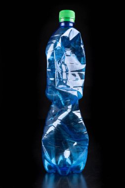 Koyu bir masanın üzerinde plastik şişe. İçme için plastik konteyner w