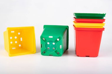 Beyaz bir masa üzerinde renkli saksılar. Bahçıvanlar için aksesuarlar.