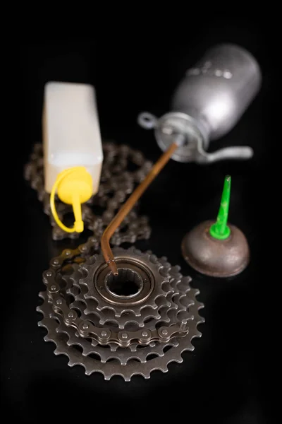 Смазка велосипедной цепи с помощью канистры масла на рабочем столе . — стоковое фото