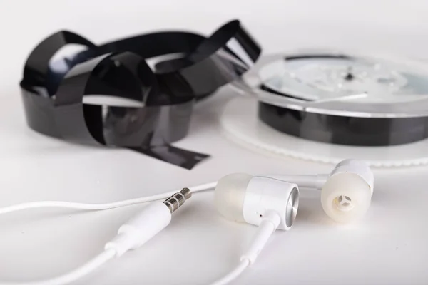 White headphones and magnetic tape with call recordings. Eavesdr