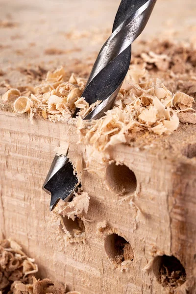 Διάτρηση οπών σε ακατέργαστο ξύλο. Ξυλουργική τρυπάνι σε μια ξυλουργική έργα — Φωτογραφία Αρχείου