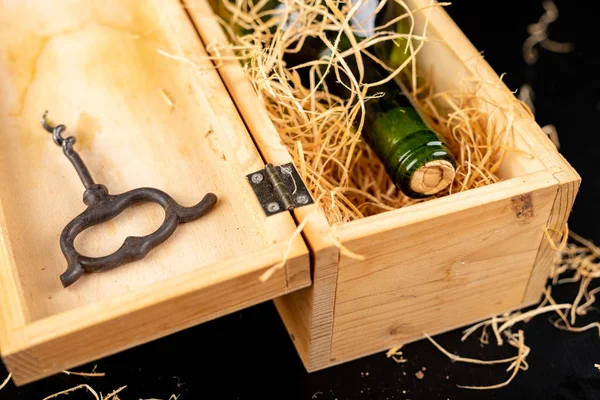 Tahta bir kutuda bir şişe şarap. Lezzetli bir alkollü içecek 