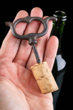 Karanlık masada bir şişe şarap ve tirbuşon. Açılış iyi w