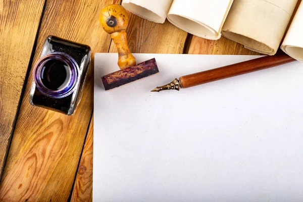 Plumilla de caligrafía de estilo antiguo, tinta y tarjeta en blanco en una mesa de madera . — Foto de Stock