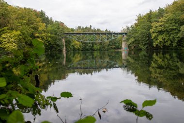 Nehirdeki durgun sulardan görülen demiryolu köprüsü. Çelik 