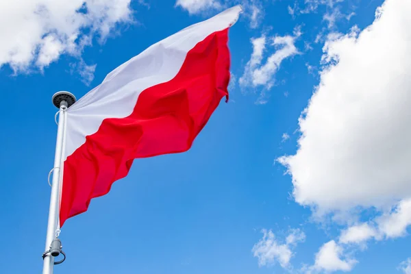 Polska flaggan på en bakgrund av molnigt himlen. — Stockfoto