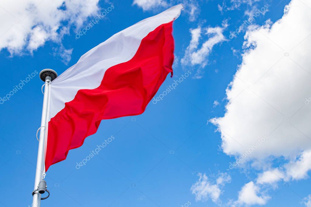 Polish flag on a background of the cloudy sky.