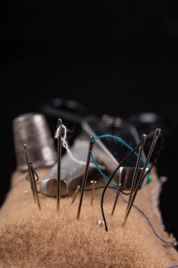 Siyah masa üzerinde eski dikiş aksesuarları. Makaslar, iplikler ve t