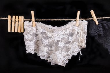 Keten bir dize üzerinde kurutma. Seksi kadın külot bir strin sabitlenmiş