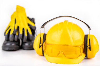 Kask, bot lar ve beyaz masaüzerinde iş eldivenleri.