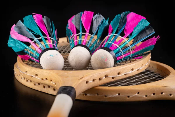 Wooden badminton rackets and shuttlecocks.