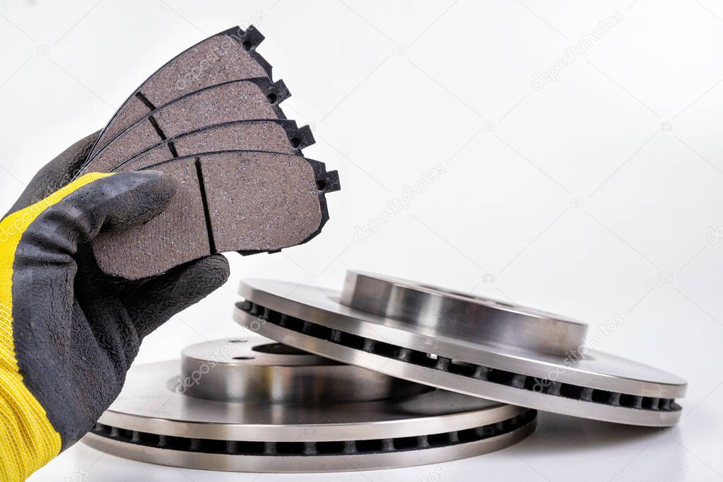 Brake pad for a passenger car in the hand of a mechanic. 