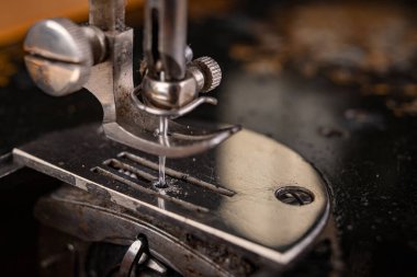 Karanlık bir masanın üzerindeki eski dikiş makinesi.. 